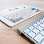 A white tablet next to a keyboard