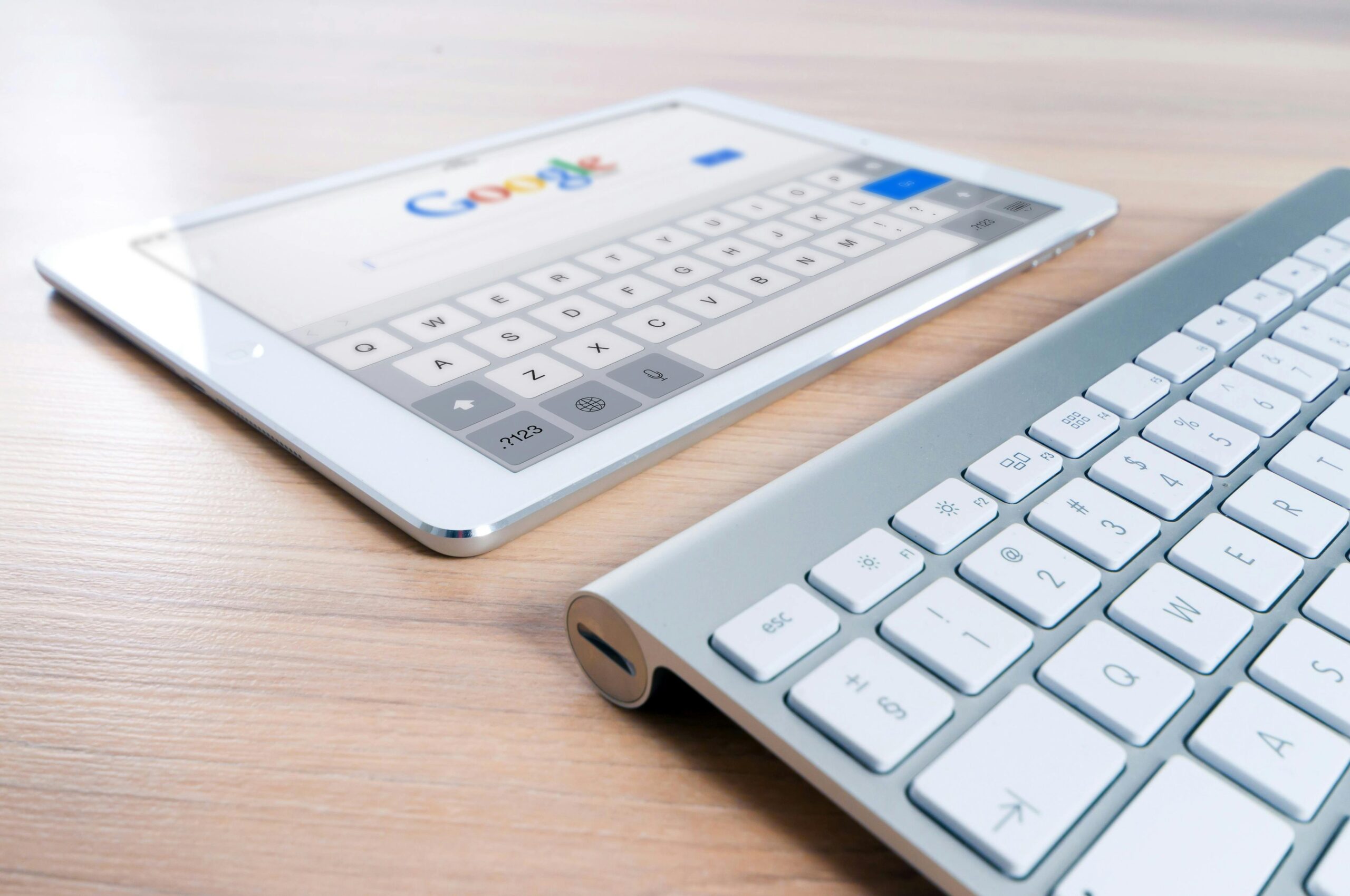 A white tablet next to a keyboard