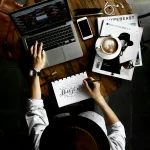 A person sitting at a table sketing a new logo and brand