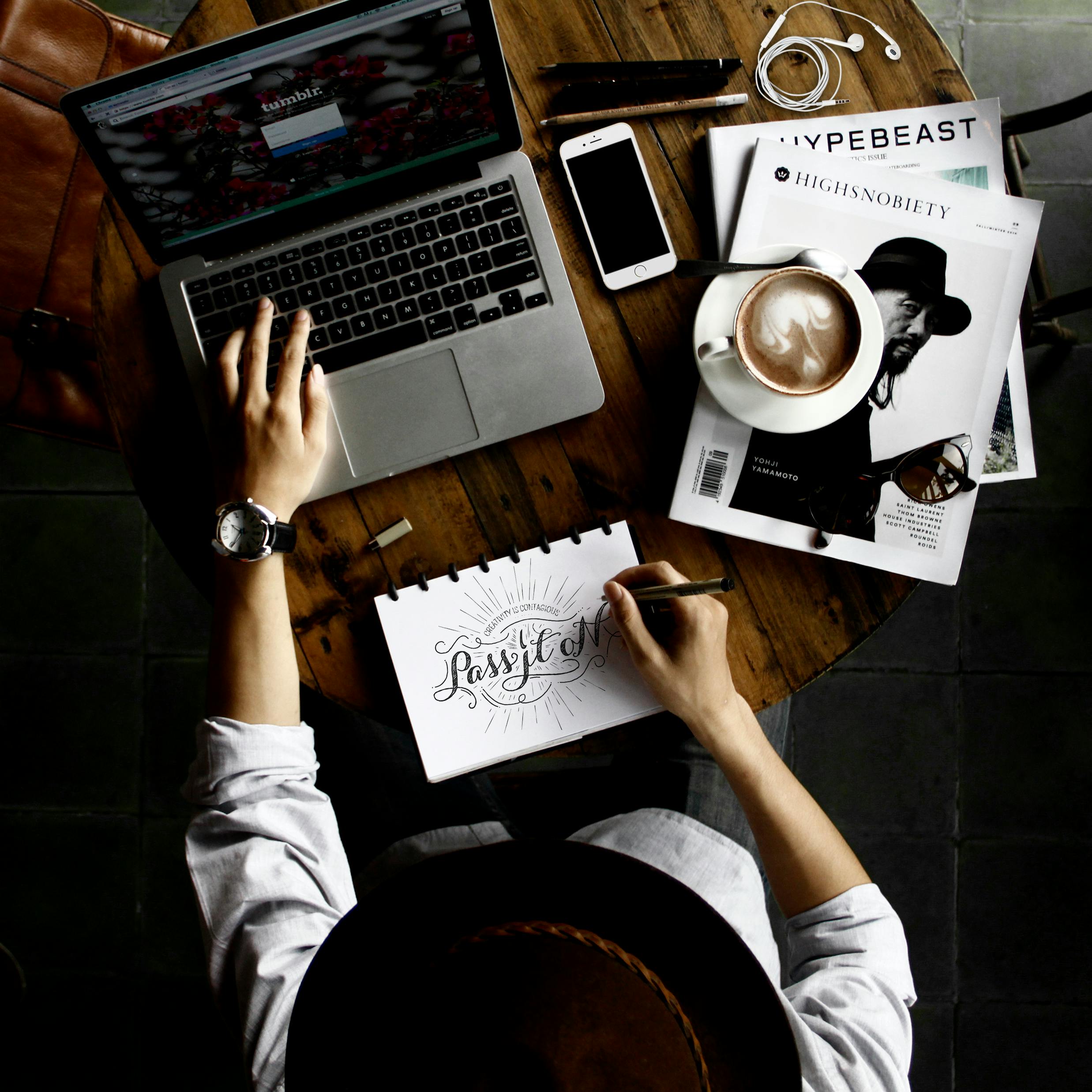 A person sitting at a table sketing a new logo and brand